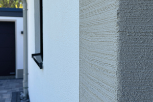  Die Einfassung von Haustür und Fenstern mit einer beigen Besenstrichstruktur sorgt für einen interessanten Akzent an der Fassade 