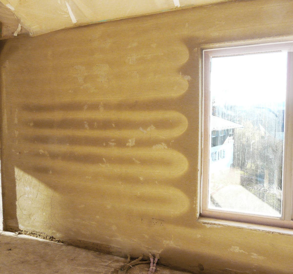 Wird zum Austrocknen der Grundputzschicht die Wandheizung eingeschaltet, zeichnen sich zuerst die Rohrbahnen hell an der Wand ab