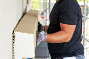  Das vorgefertigte Fassadenprofil setzen Handwerke-rinnen und Handwerker in den frischen Klebemörtel ein und richten es exakt aus 