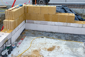  Schutz des aufgehenden Lehmsteinmauerwerks durch zwei Horizontalsperren und Verwendung von wasserfesten Steinen als Kimmschicht 