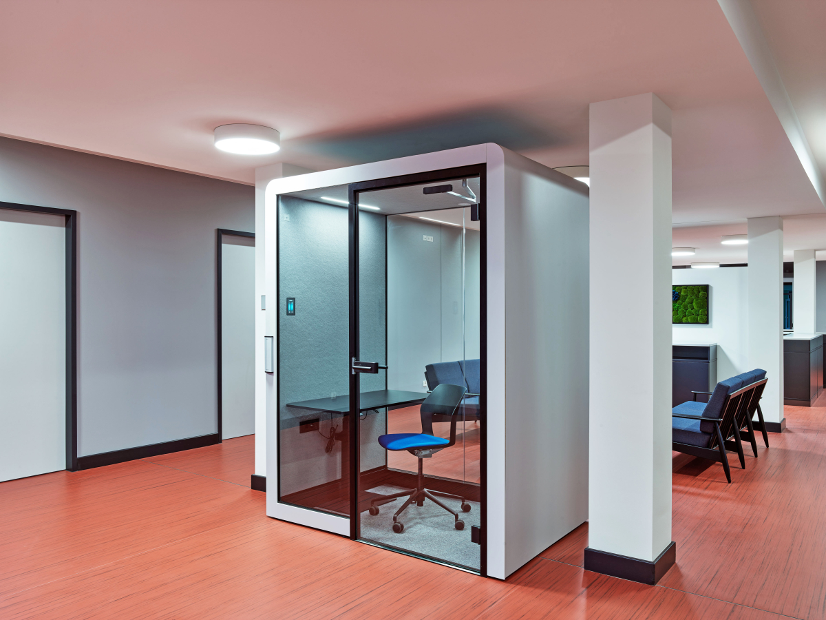 Eine Einzelkabine sowie eine offene Arbeitsfläche im neuen NewWork-Bereich der Verwaltung