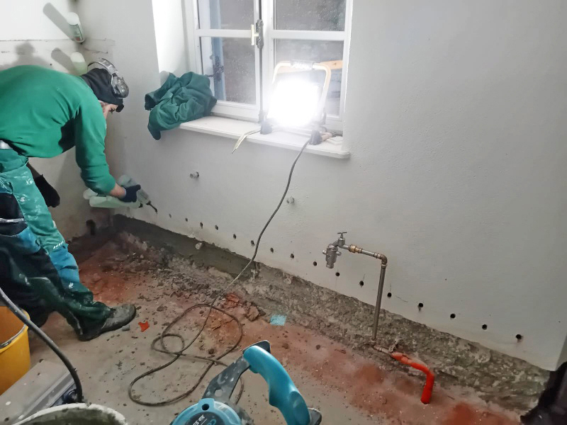 Zunächst wurde an allen Außenmauern eine Horizontalsperre gegen saugende, aufsteigende Feuchtigkeit durch drucklose Applikation im Bohrlochverfahren eingebaut