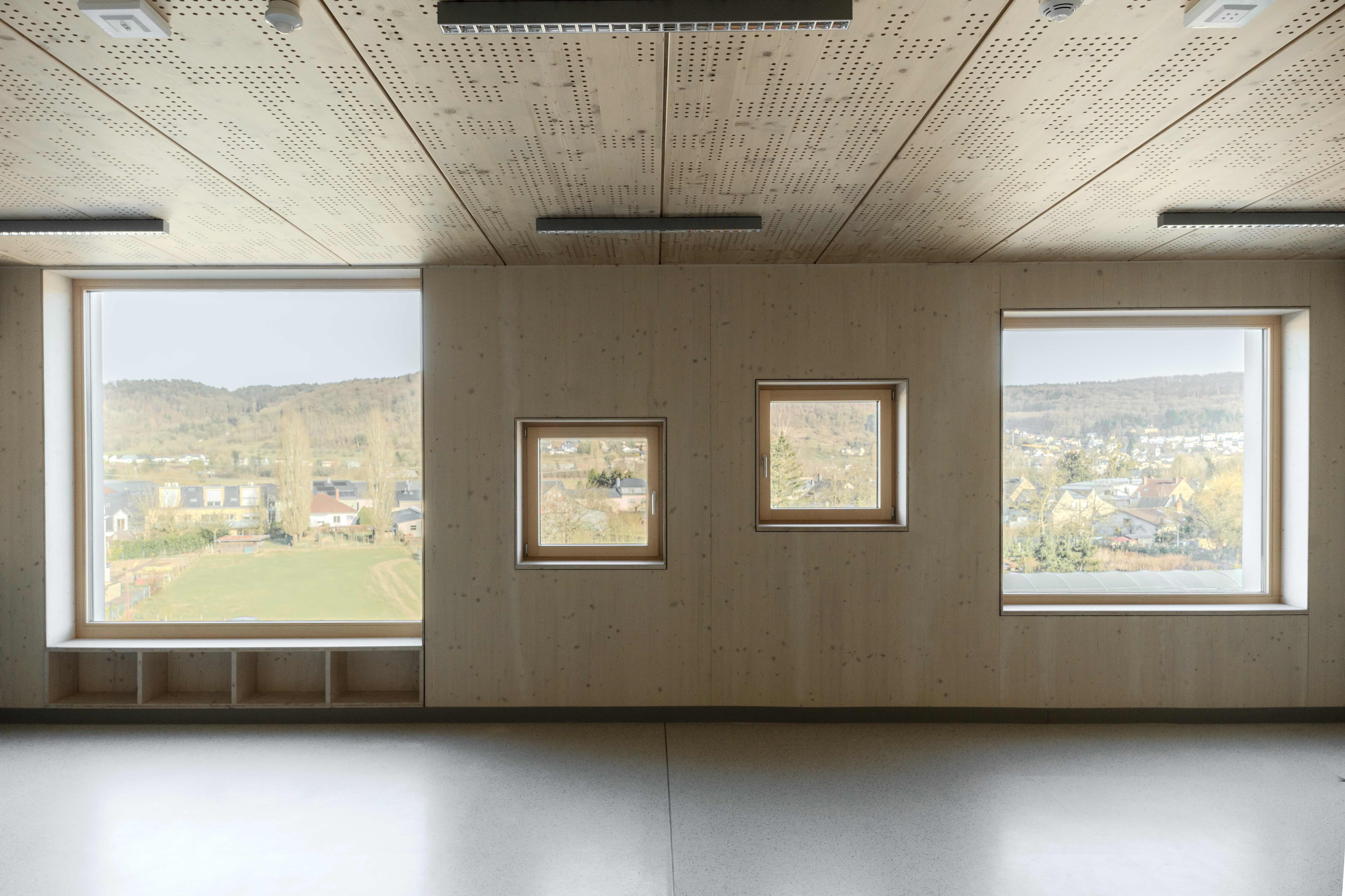 Natürliche Oberfläche, bestens brandgeschützt: In der Schule Prënz Charles sorgen die Sichtholzwände und großzügige Fensterflächen für ein helle, freundliche, einladende und sichere Lernatmosphäre