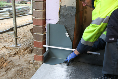 Schutz der Fensterecke während der Bauphase mit einem Stein