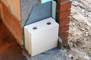  Schutz der Fensterecke während der Bauphase mit einem Stein 