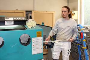  Per Sandstrahlung werden Fensterelemente gereinigt. Der 20-Jährige Maximilian lernte, die Maschine zu bedienen und zeigt, welche Effekte erzielt werden 