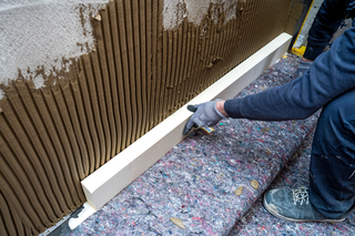 Ansetzen der kapillaraktiven Innendämm-Paneele ?iQ Therm 2.0? mit  ?iQ M universal? als Klebe- und Armierungsspachtel