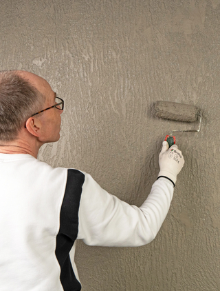 Mit dem Lasuranstrich mit ?Versico 82? schließen Handwerkerinnen und Handwerker die Arbeiten ab