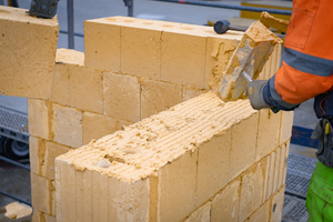  Auftrag des Lehmdünnbettmörtel mit einer Mörtelkelle 