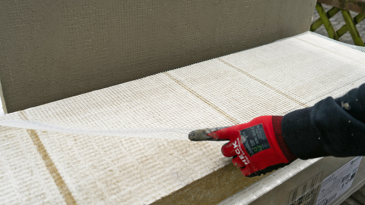 Zusätzlich werden vorgefertigte Zuschnitte vom Separationsgewebe auf die Rückseite der Dämmplatten gelegt