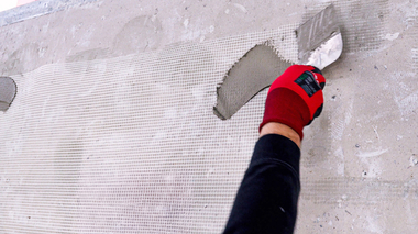 Anbringen: Das Separationsgewebe wird auf dem Mauerwerk nicht überlappend angebracht, zum Beispiel punktuell mit Klebemörtel