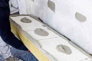  Anschließend wird der Kleber im Punkt-Wulst-Verfahren aufgetragen und die Platte an die Wand gedrückt 