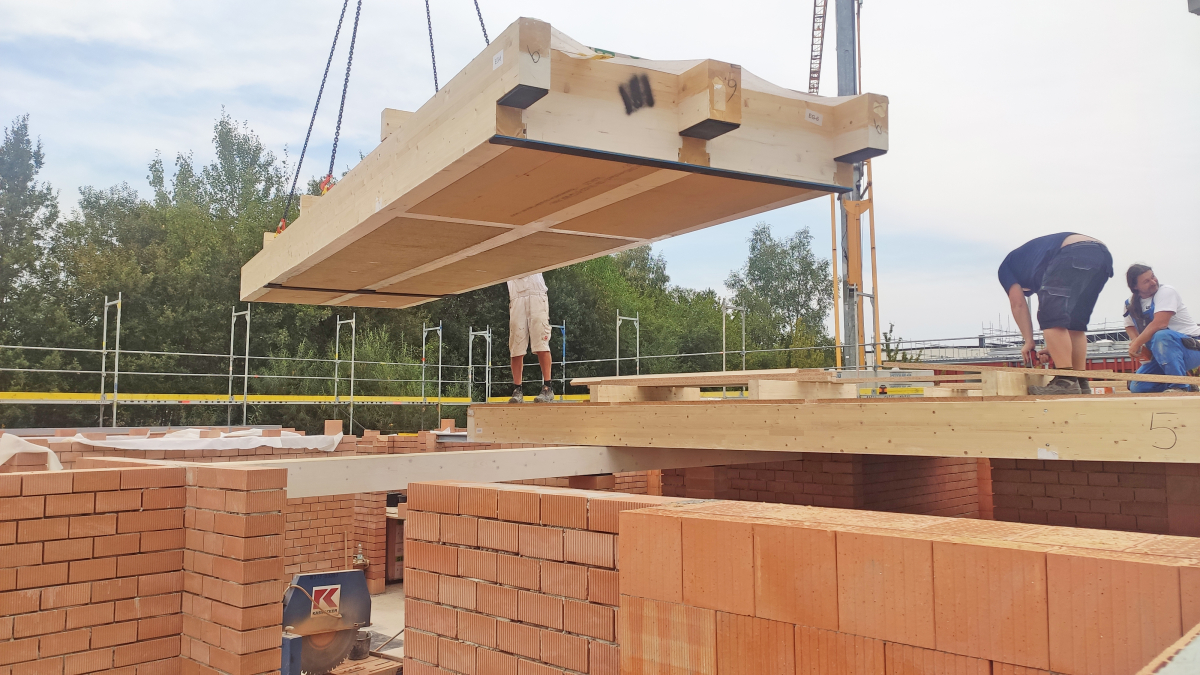 Verhebeprozess eines Elements einer Holz-Lehm-Massivdecke auf der Baustelle