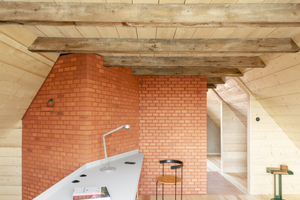  Erschließungskern aus Ziegeln im Obergeschoss und Arbeitsplatz an der Galerie zum Luftraum über dem Erdgeschoss 