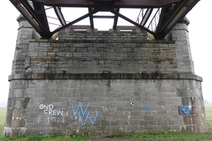  Ein geschädigter Natursteinpfeiler der Brücke vor Beginn der Sanierung: Risse, Auswaschungen, Feuchtespuren und biogener Bewuchs zeigen den fortgeschrittenen Substanzverlust nach jahrzehntelangem Verfall 