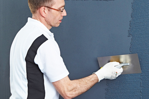  Nach dem Zwischenanstrich tragen die Handwer-kerinnen und Handwerker mit dem ?Edelstahlglät-ter 3792? Putz im passenden Farbton auf die Flä-che auf 