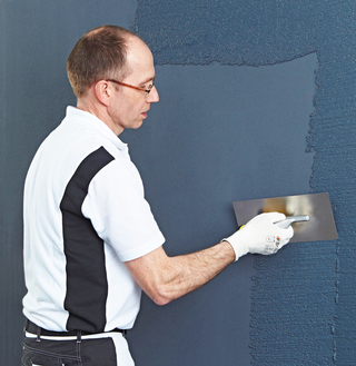 Nach dem Zwischenanstrich tragen die Handwer-kerinnen und Handwerker mit dem ?Edelstahlglät-ter 3792? Putz im passenden Farbton auf die Flä-che auf