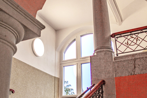  Die eingesetzten Glasrahmenelemente lassen Tageslicht tief in die Flurzone und schaffen klare, zurückhaltende Übergänge im denkmalgeschützten Schulbau 