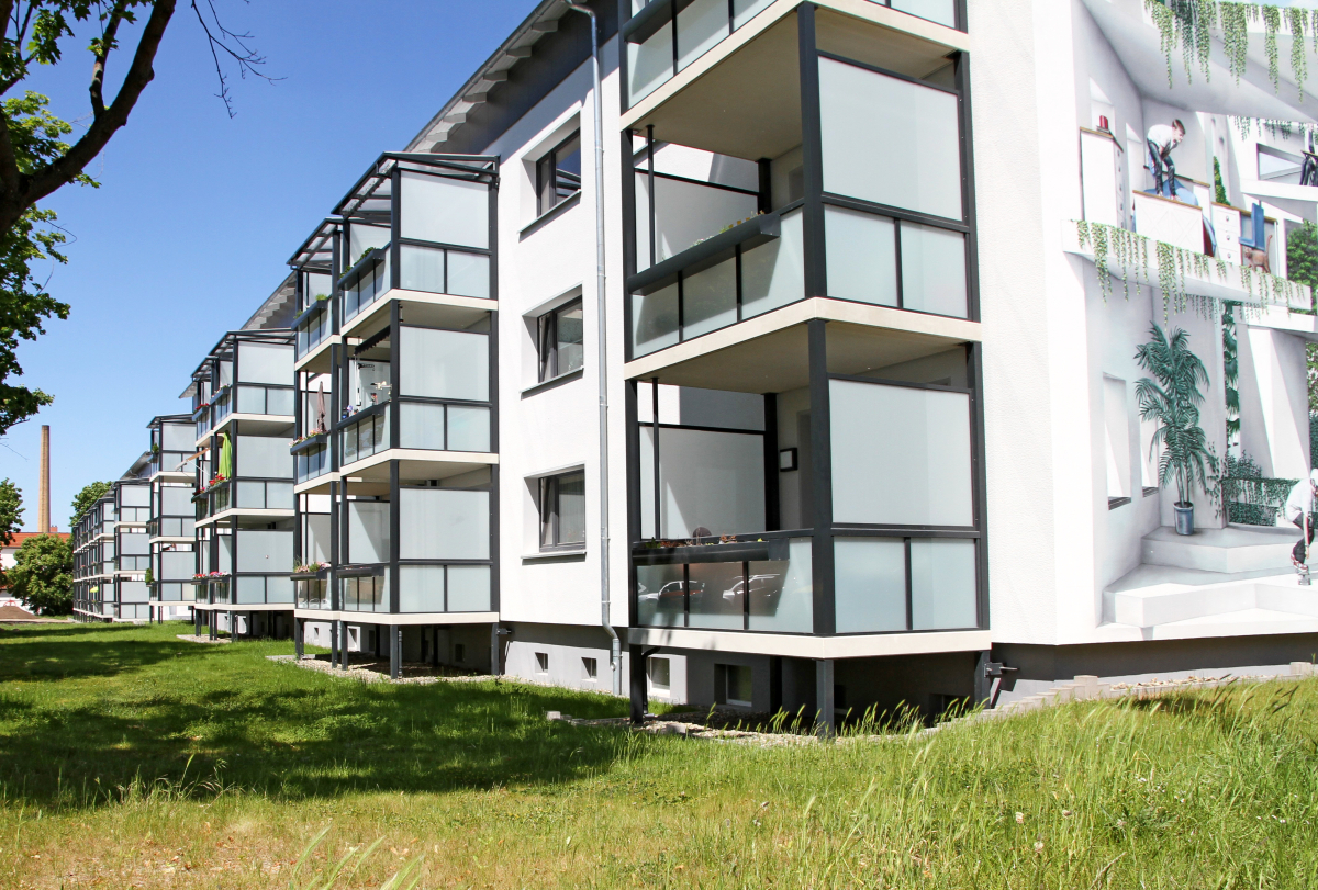 Der ehemalige Plattenbau ist nun ein modernes Energieeffizienzhaus mit künstlerisch gestalteten Fassaden und verbessertem Wohnkomfort