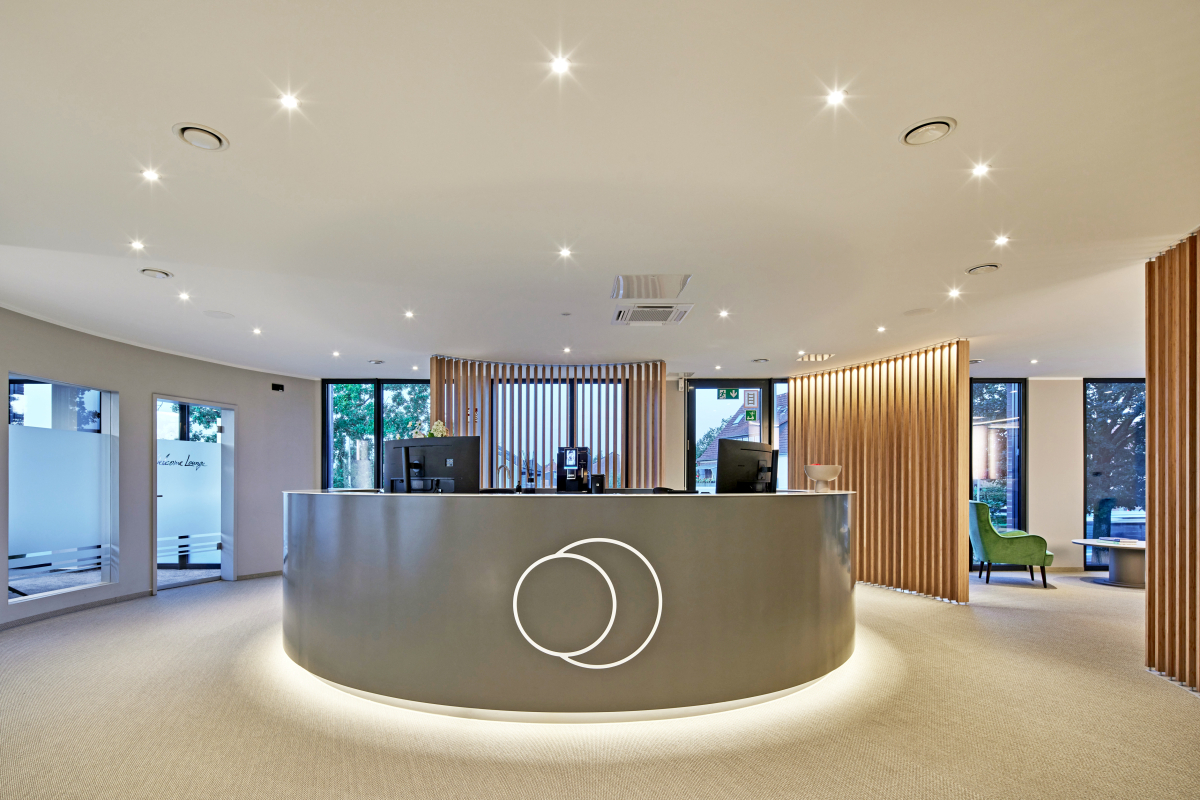 Ein großzügiger, modern gestalteter Eingangsbereich gibt den Patientinnen und Patienten mit ruhigen Farben und klaren Strukturen Sicherheit