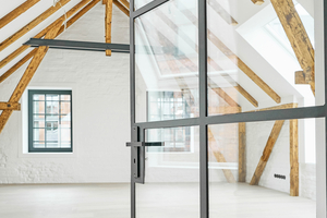  In der ehemaligen Lagerfläche der Wäscherei treffen in den beiden Wohnungen die freigelegte Dachkonstruktion mit über 120 Jahre alten Sparren auf moderne Interiors 