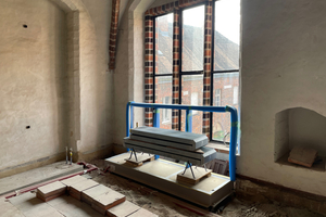  Die unverkleideten Konvektoren stehen am Ende vor der Wand. Der noch blau verpackte Anprallschutz schützt die Fenster ohne Sicherheitsglas 