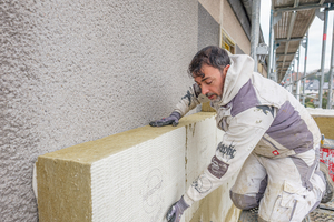  Der Handwerker drückt die Steinwolle-Dämmplatten vollflächig an die Fassade 
