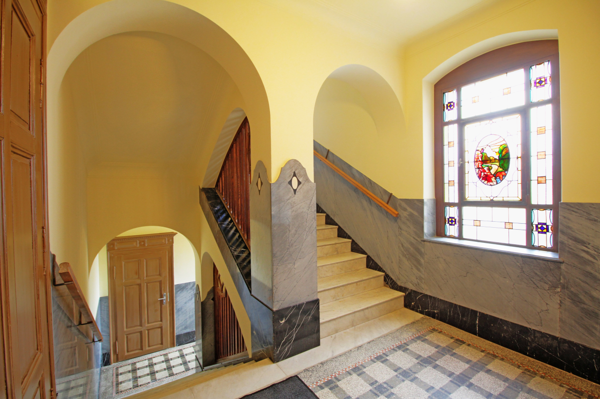 Der großzügige Bau mit Terrazzo-Treppenhaus, farbigen Steinverkleidungen und bleiverglasten Fenstern spiegelt den Wohlstand seines Erbauers, des Textilfabrikanten Theodor Steinbach, eindrucksvoll wider