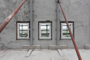  Von innen abgestützte Backsteinmauer mit bereits eingesetzten neuen Isolierglasfenstern 