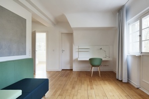  Apartment 2: Der Farbklang dreier Grüntöne in Kombination mit einer grauen, lebendig strukturierten Fläche bildet einen ausgleichenden Kontrast zum warmtonigen Holzboden 