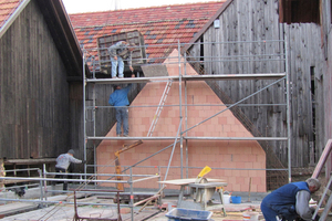  Die Handwerker bereiten das Betonieren des Ringankers auf der Mauerkrone der aus Hochlochziegeln neu errichteten Giebelwand der Scheune vor 