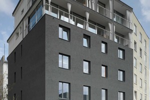  Das vor 105 Jahren in München-Schwabing erbaute Mehrfamilienhaus wurde um zwei Geschosse aufgestockt. Die Fassade erhielt eine grobkörnigen Modellierputz in einem Graphitton, in den die Maler abschließend Effect-Sand einstreuten 