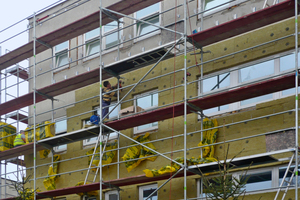  Handwerker bringen die mineralische Dämmung in einer Dicke von 100 mm an 