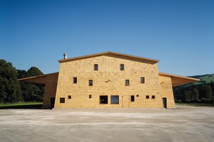  Die zum Dorf gerichtete Fassade springt aus dem Baukörper hervor und wurde in Anlehnung an die örtliche Bautradition verschindelt. Die 16 x 60 cm großen Überformat-Schindeln fertigten die Zimmerleute aus Restholz 