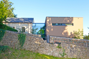  Ansicht des Ensembles vom Verlauf der Ohlsche, eines mit Naturstein eingefriedeten historischen Pfades im Dresdner Ortsteil Wachwitz (vor und nach dem Umbau): Durch farbliche Harmonie und den Kunstgriff der gläsernen Verbindungsfuge gelingt der Dialog zwi 