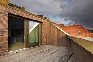  Die Deckschale der Hebe-Schiebe-Tür zur Dachterrasse ist passend zum Kupferblech der Dachdeckung wie die Holz-Aluminium-Fenster der Fassade in bronzefarben eloxiertem Aluminium ausgeführt 