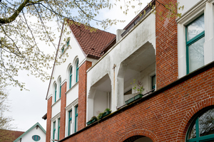  Der ländliche Charakter der Gartenstadt mit ihrem Baumbestand und der von der Nordsee geprägten feucht-kühlen Witterung hat ihren Preis: Außer der Zeit hat die Algen- und Sporenbildung den Fassaden zugesetzt 