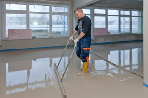  Durch das Einebnen mit der Schwabbelstange fließt der feinkörnige Mörtel gut in die Noppen der Folienelemente, deren Verklebung das Aufschwimmen der Heizung verhindert  