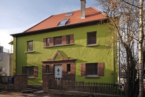  Die Sanierung betont den expressiven Charakter der Straßenfassade. Der originale Rillenputz in neuem frischem Grün zeigt alte Handwerklichkeit und kontrastiert mit den erdfarbenen Klinkern 