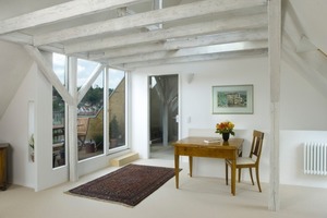  Der Dachraum mit sichtbaren Bestandsbalken und Balkon mit Flanken aus Furnierschichtholz 
