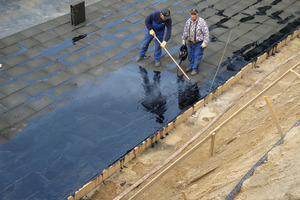  Auftragen des Bitumendeckabstrichs auf die lastabtragende Wärmedämmung aus Schaumglas. Die Foamglas-Platten wurden zuvor mit Heißbitumen auf die abgebundene Magerbetonschicht aufgeklebt  