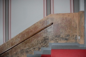  Im Treppenhaus stellten die Maler die historische Wandmalerei wieder her. Der untere Wandabschnitt dokumentiert hingegen die freigelegten über hundertjährigen Farb- beziehungsweise Zeitschichten 