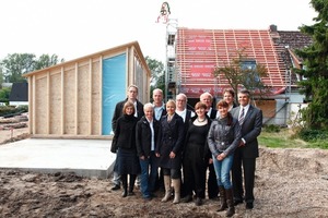  Rechts: Am 17. September war Richtfest. Ein Teil der Erweiterung in Holzbauweise steht bereits (links im Bild). Im Bildvordergrund die Velux-Mitarbeiter, Architekten und Handwerker 