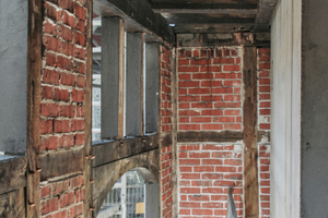  Blick in die Remise: Links im Bild das mit Ziegel gefüllte Fachwerk, recht der Stahlbeton das Aufzugsschachtbaus 