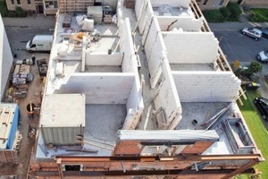  Die Baustelle aus der Luft: Auf das mit neunen Innenwänden und Zwischendecke gefüllte Gebäude setzten die Zimmerleute den neuen Dachstuhl auf 