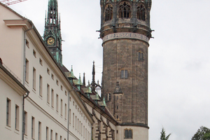  Der Kirchturm der neoromanischen Schlosskirche, dessen Haube und Spitze unentschieden zwischen einer Krone und einer Pickelhaube schwankt 