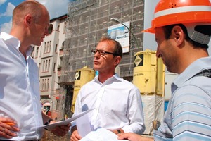  Peter Aping (in der Mitte) im Gespräch mit dem Bauleiter Uelver Sava von der Firma Figo (rechts) und Thomas Wieckhorst, verantwortlicher Redakteur der BAUHANDWERK (links). Im Hintergrund das eingerüstete ehemalige Haus der Einheit in Berlin<br /> 