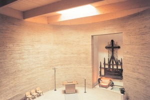  Der fertige Innenraum der Kapelle der Versöhnung verströmt durch die warme Ästhetik der Stampflehmwand eine besondere Atmosphäre<br /> 