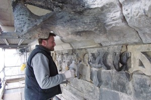  Partielle Festigung sandender Teile im Zierfries mit der Pipette. Der Wasserspeier (oberhalb des Restaurators) mit extremer Schädigung 