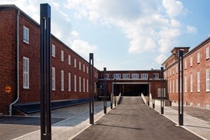  Der Blick auf das Tor zur großen Verladehalle wird von den Flügelbauten und, nach der Umnutzung zum Lenkwerk, auch von Lichtstelen flankiertFotos: Thomas Rieth 